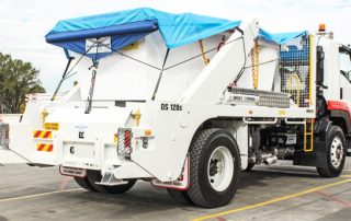 White skip loader with blue tarp