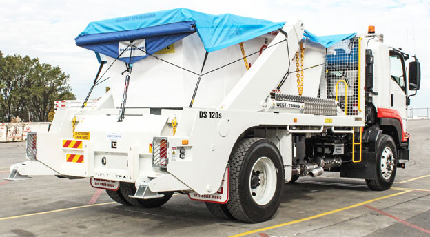 White skip loader with blue tarp